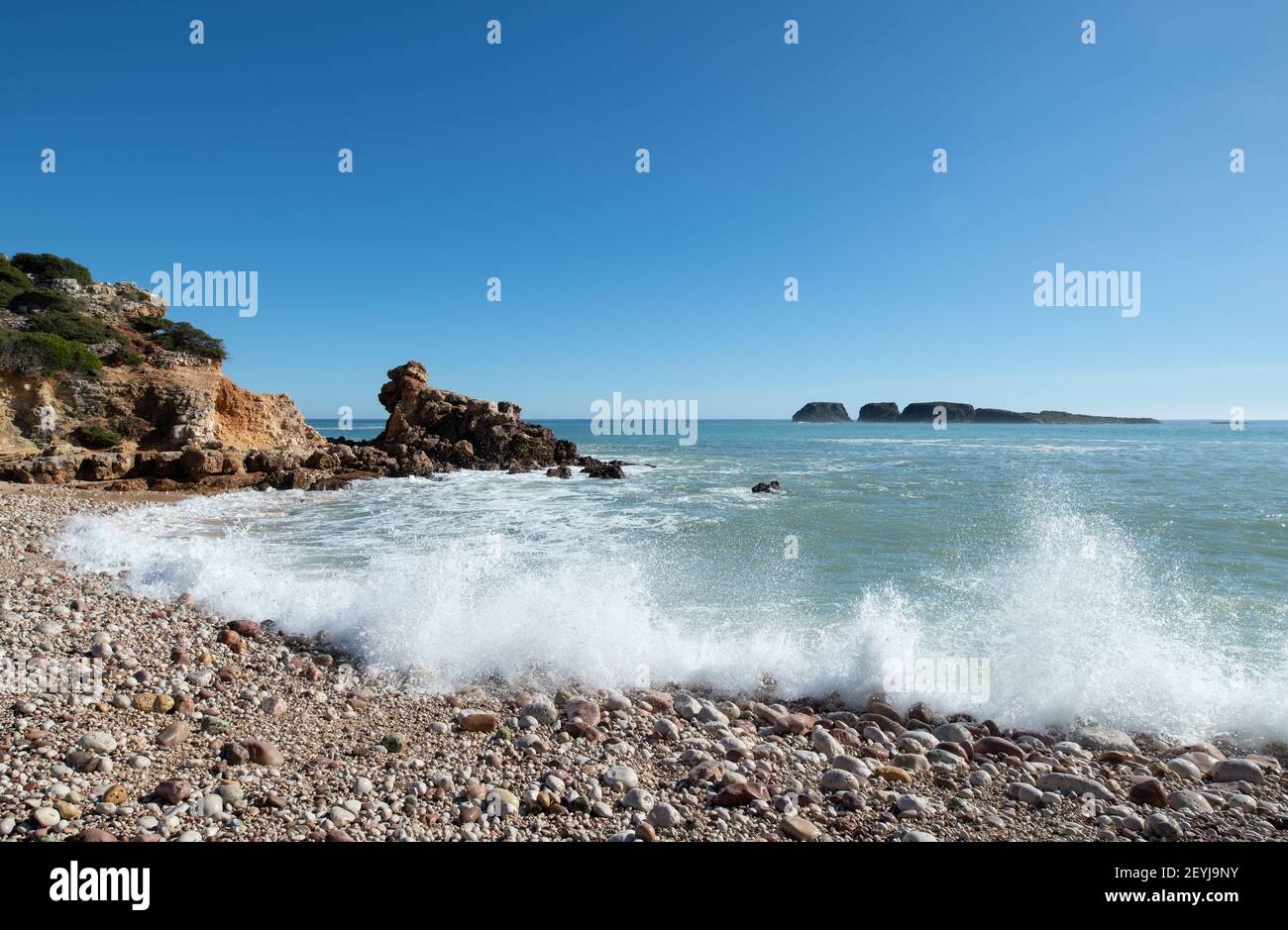 waves splashing onto a pebble beach in winter Stock Photo