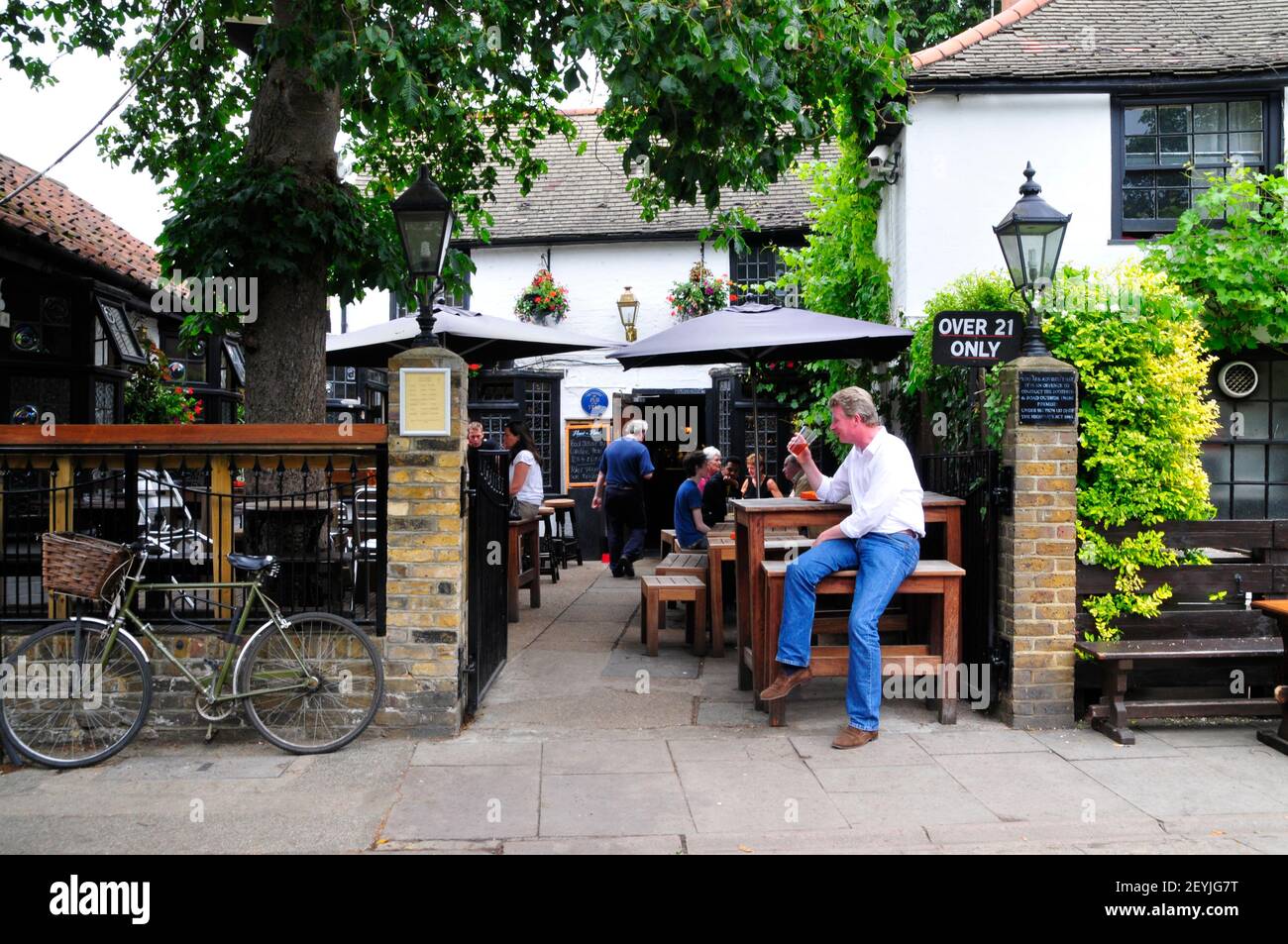 A man drinking a pint of beer outside The Hand and Racquet pub, Wimbledon, London, England Stock Photo