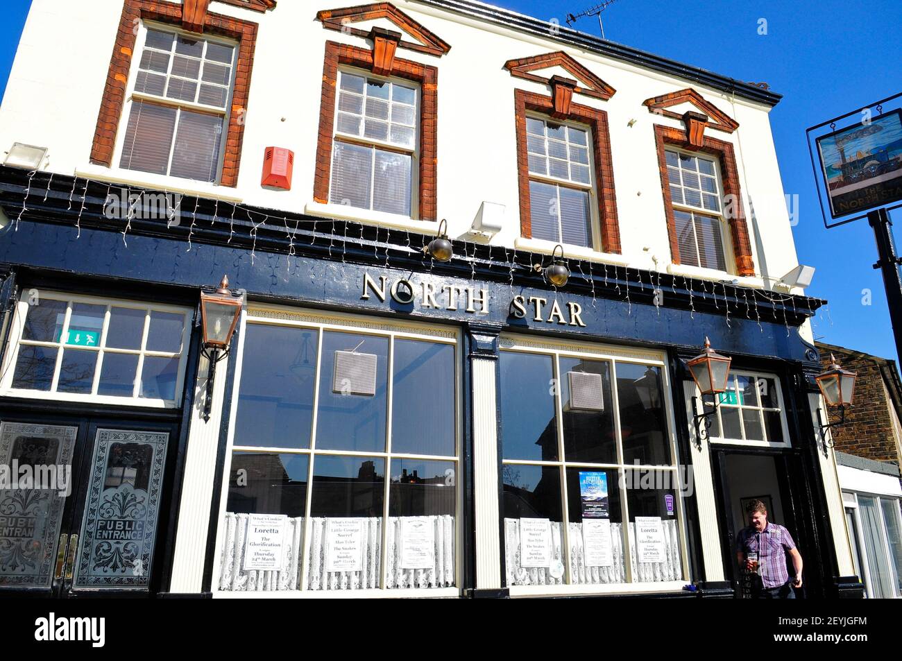 A man coming out of The North Star pub in Leytonstone, London, England Stock Photo