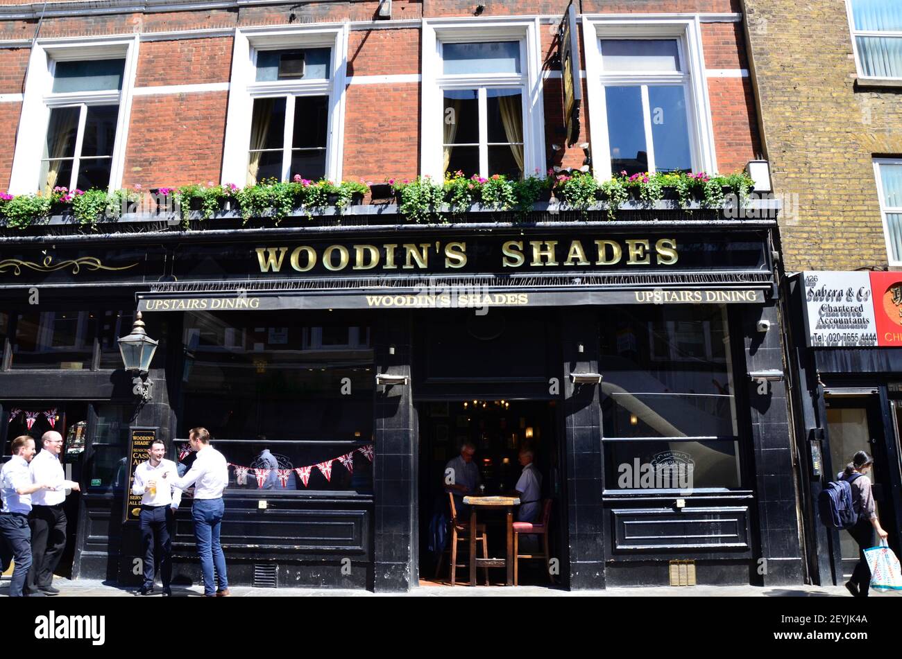 Men chatting outside the Woodin's Shades  pub in London, England Stock Photo