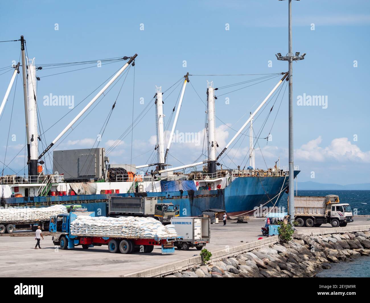 Trucks with salt waiting to load onto a tuna carrier vessel at the fishing port of General Santos City, Tuna Capital the Philippines. Salt is used as Stock Photo