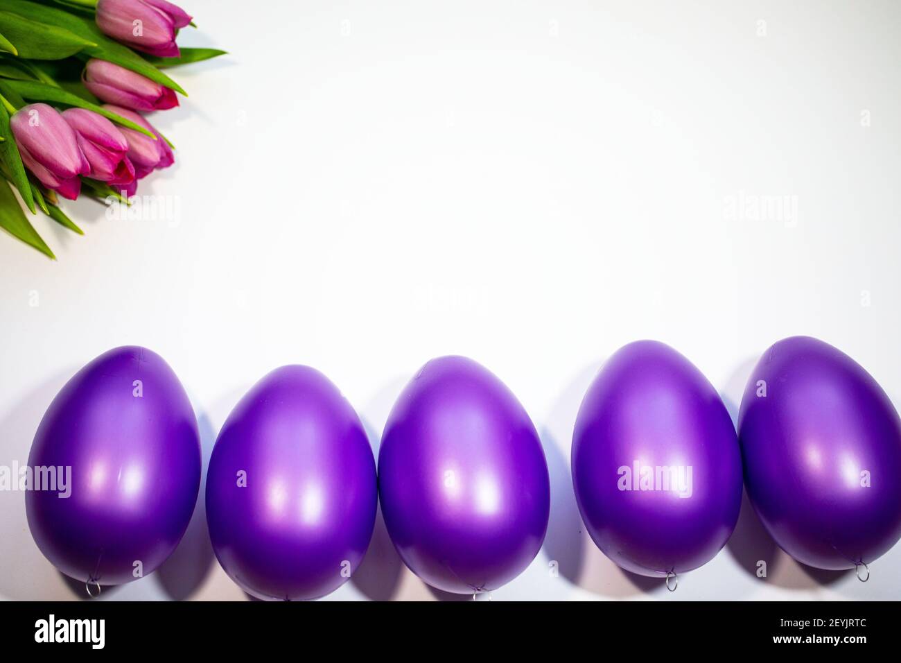 Easter eggs with tulips on a white background Stock Photo - Alamy