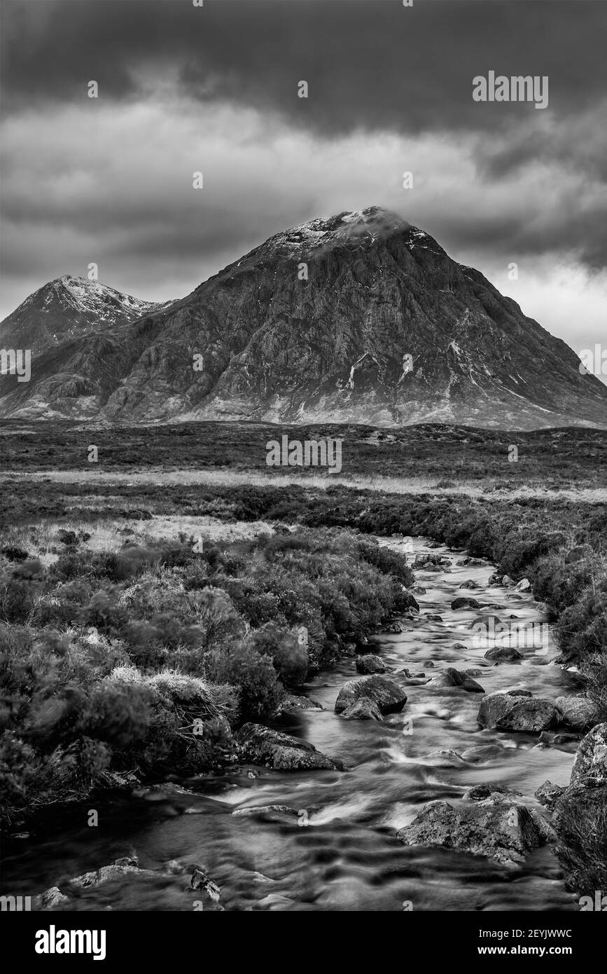 Epic  black and white dramatic landscape image of Buachaille Etive Mor and River Etive in Scottish Highlands on a Winter morning with moody sky and li Stock Photo