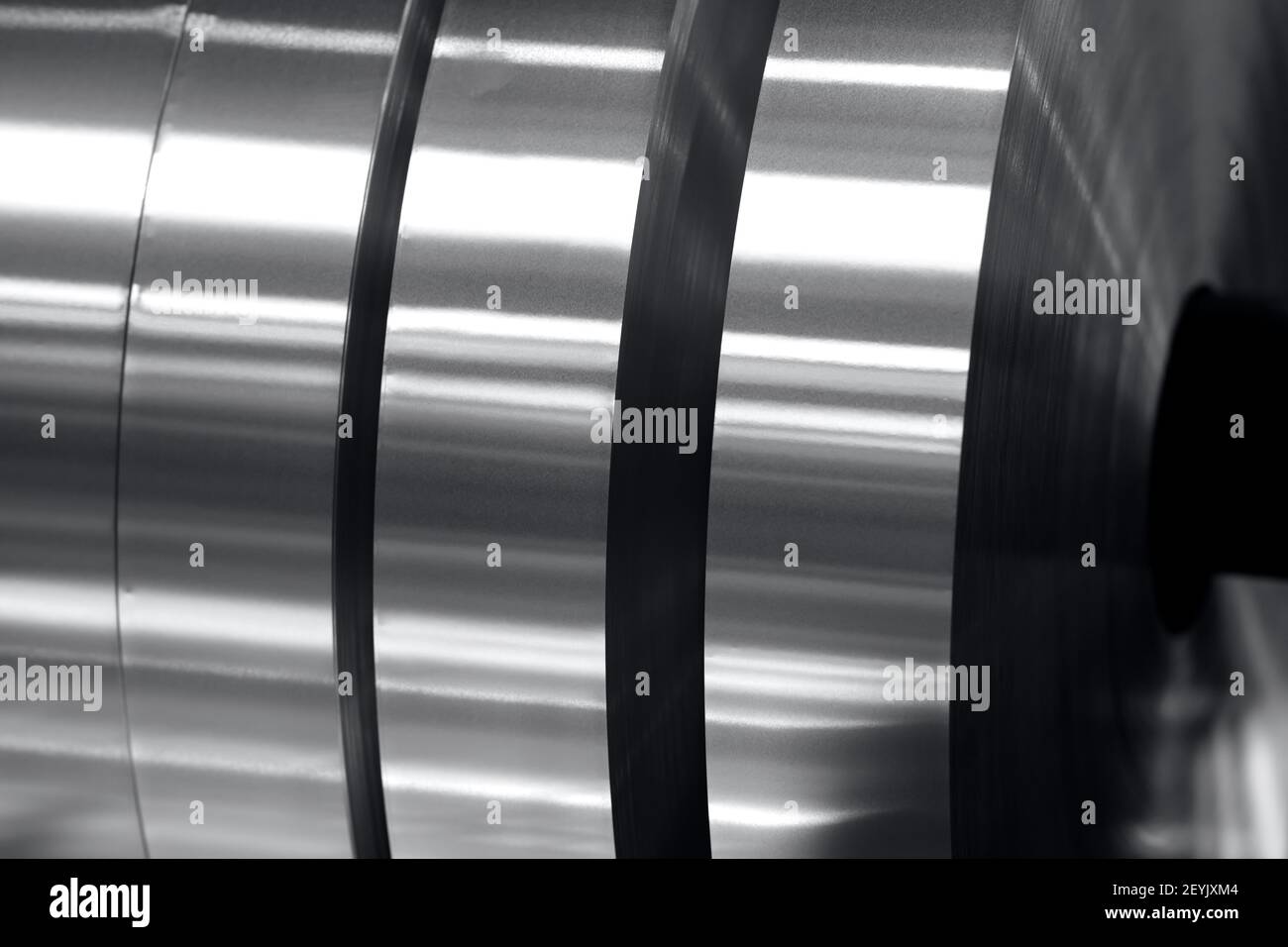 aluminum strips wound on coils, industrial background photo in black and white Stock Photo