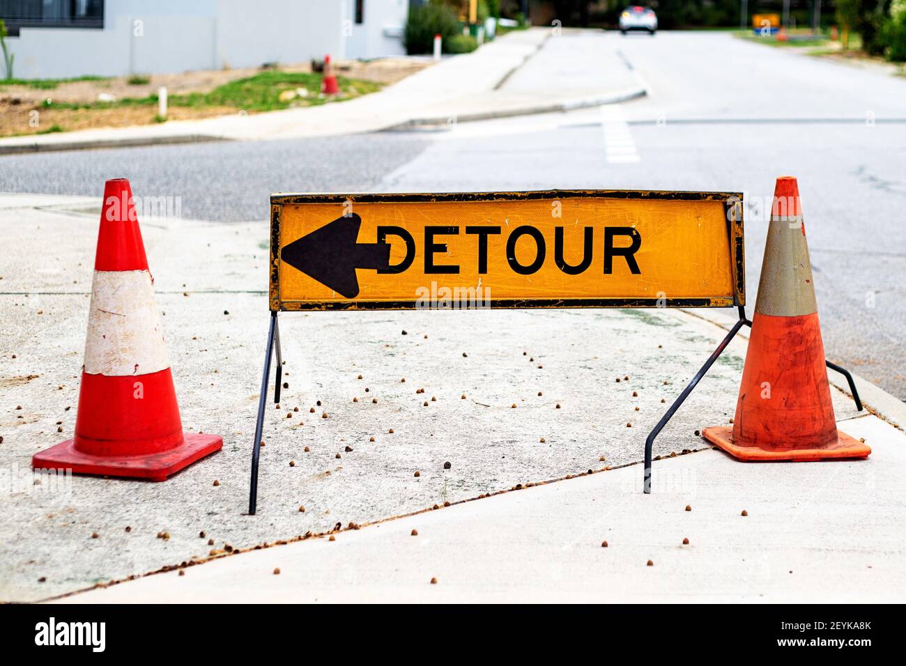 Yellow road detour sign between two traffic cones Stock Photo