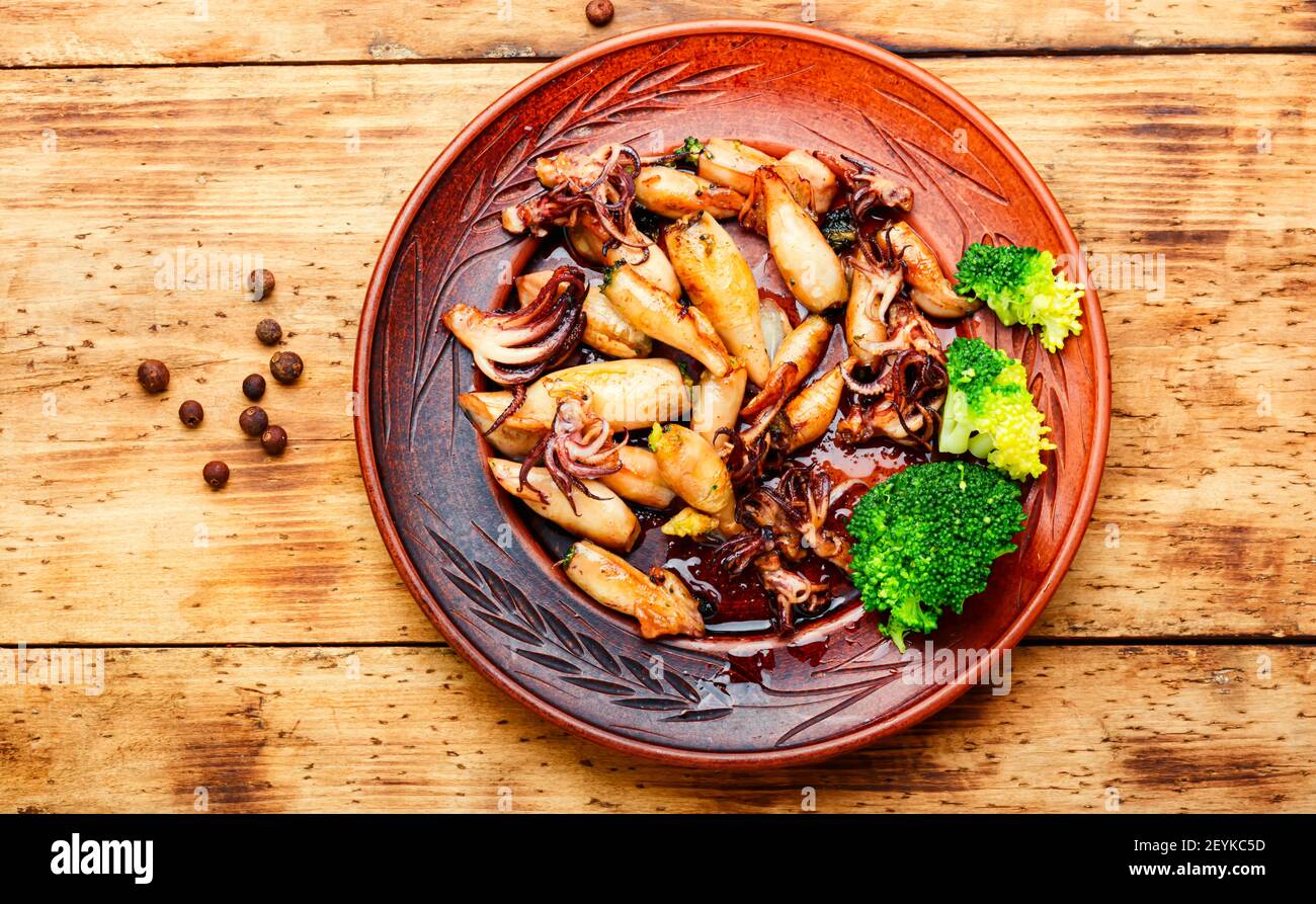 Baked squid stuffed with broccoli.Grilled calamari with vegetables