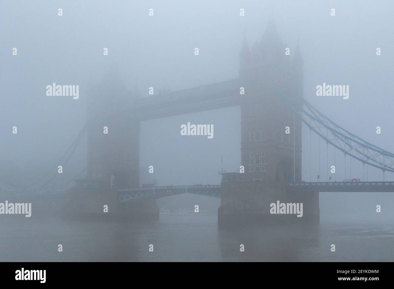 The iconic Tower Bridge and the River Thames shrouded in mist, creating a wonderfully gothic vision, reminiscent of the London of yesteryear. - Stock Image