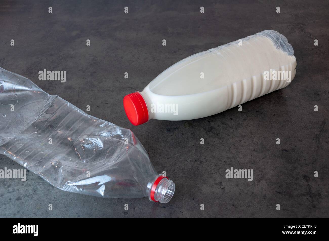 Unlabeled milk bottle laying on side, squashed used plastic bottle for