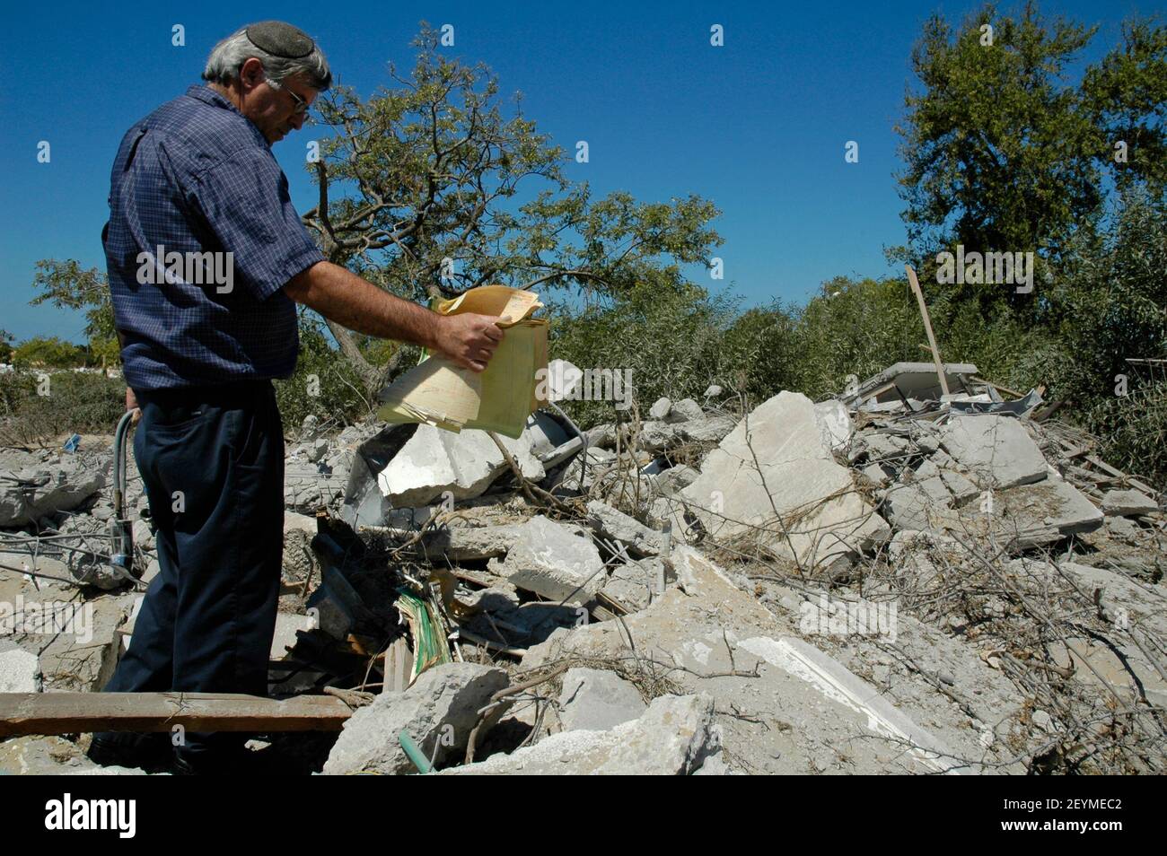 An Israeli man search through mounds of rubble of demolished houses in what used to be the Jewish settlement of Neve Dekalim in Gaza Strip on 06 September 2005. Israel completed the evacuation of all 8,000 Jewish settlers from Gaza and several hundred more from four enclaves in the northern West Bank, after nearly 40 years of occupation. Stock Photo