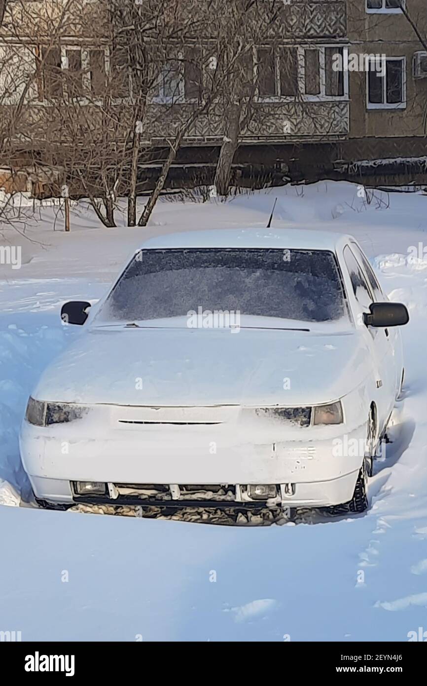 Snowcovered white car with low ground clearance Stock Photo Alamy