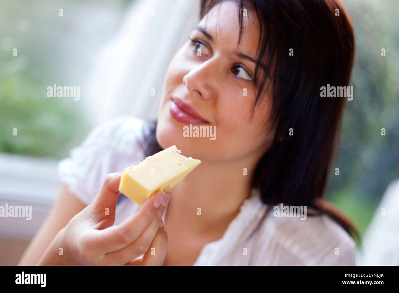 Woman eating cheese Stock Photo