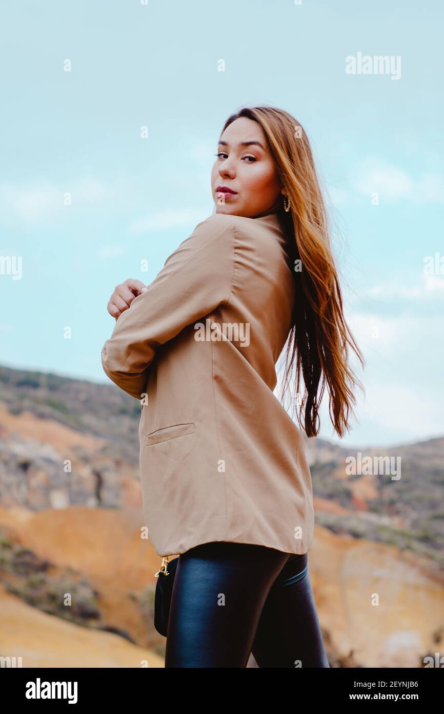 A vertical shot of a fashionable female posing on the Sabrinsky Desert stones in Colombia Stock Photo