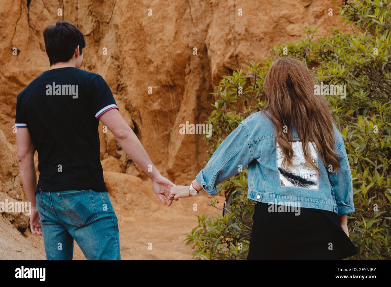A back view of a couple holding hands at the Sabrinsky desert in Colombia Stock Photo