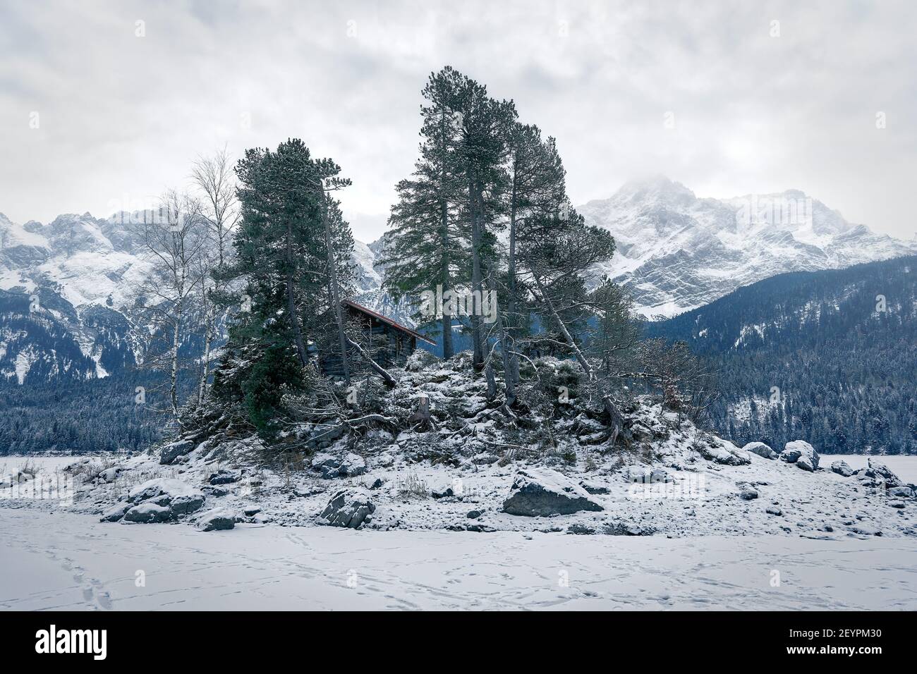 Island in Frozen Lake Eibsee with Zugspitze on Winter Day Stock Photo