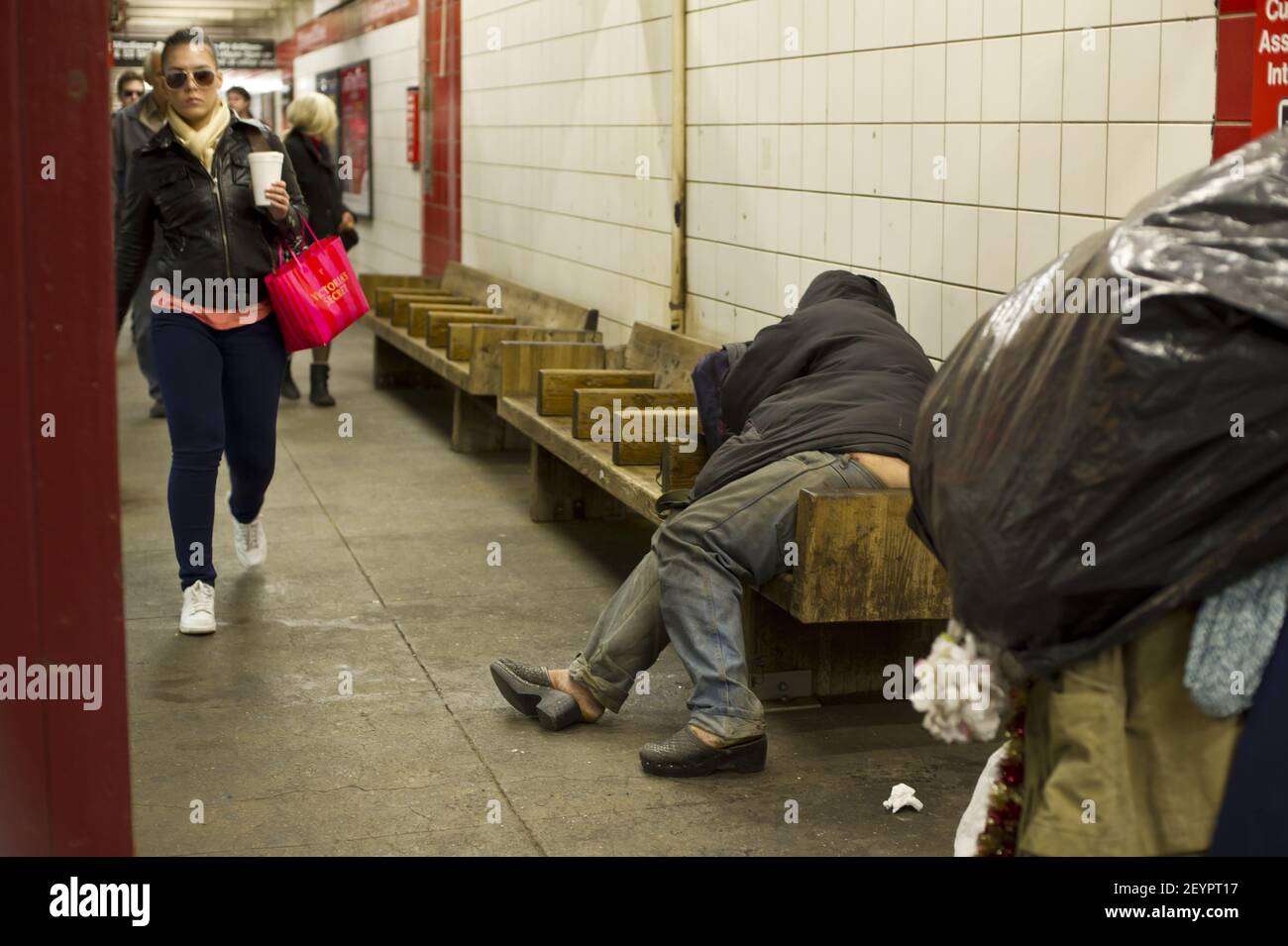 A homeless men asleep on a bench in the 5th Avenue subway station in ...