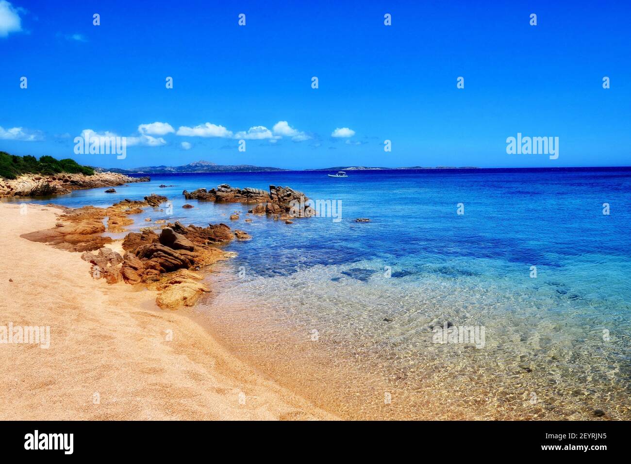 Sea With Rocks A breathtaking view of a sea with rocks on the shore under the blue sky ...