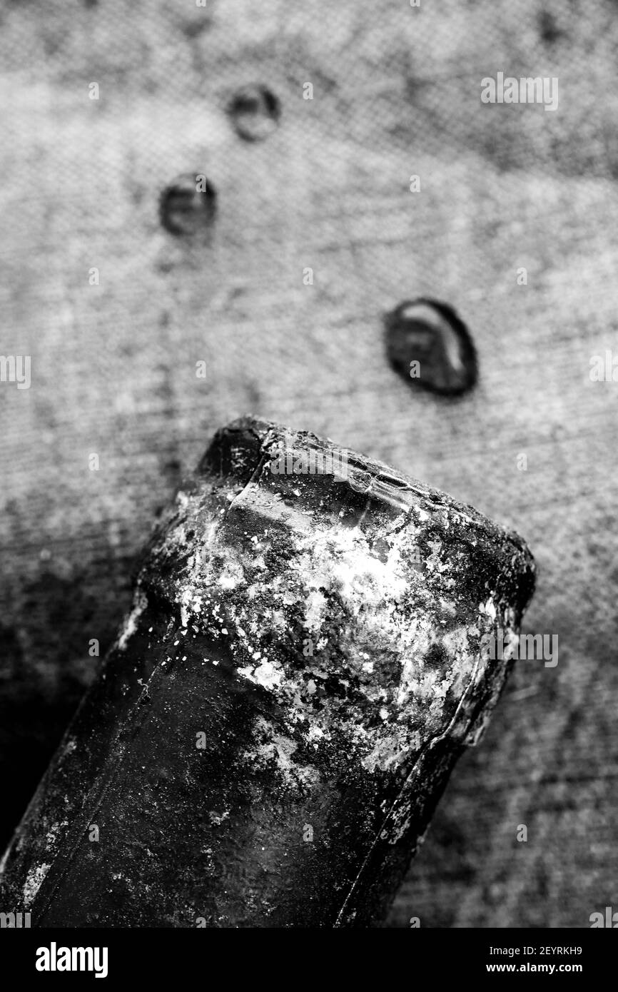 Bottleneck of an old red wine bottle with drops of wine laying of a