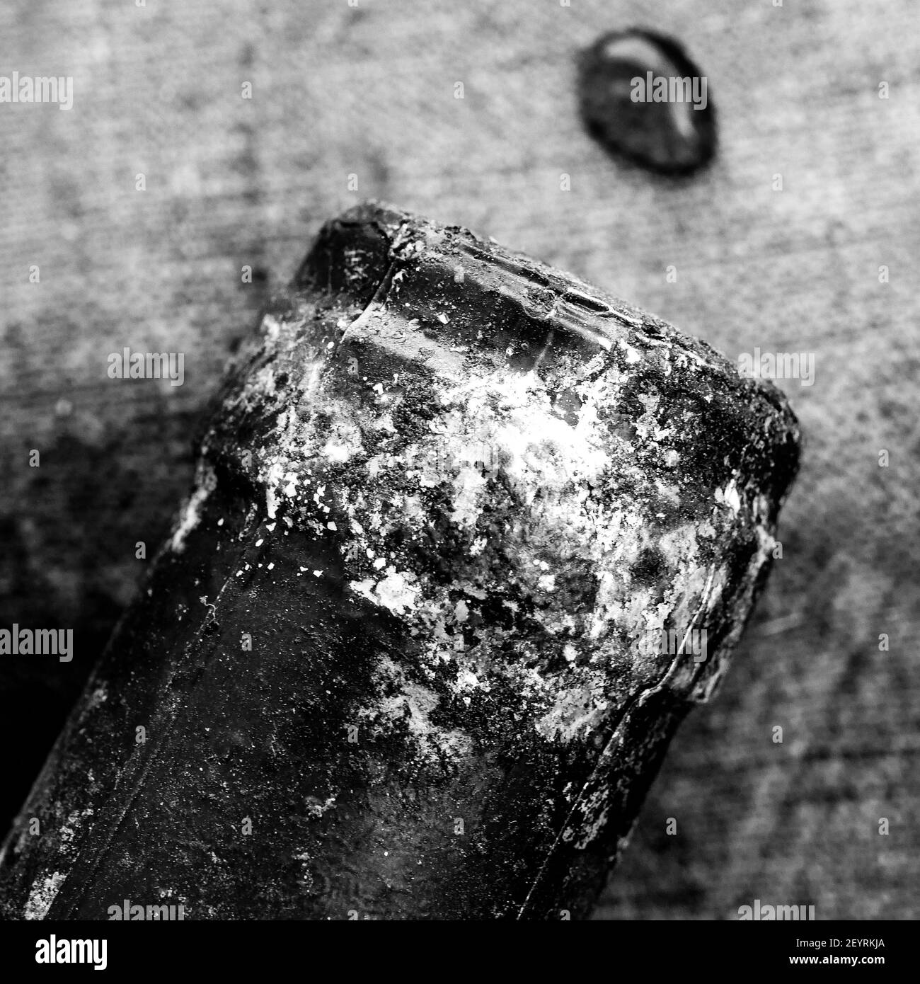 Bottleneck of an old red wine bottle with drops of wine laying of a