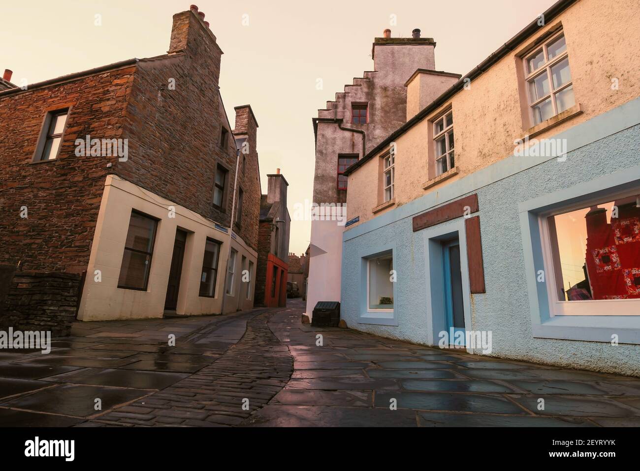 Wide angle view of narrow street and vintage blue and white houses in Stromness on Orkney island in northern Scotland Stock Photo