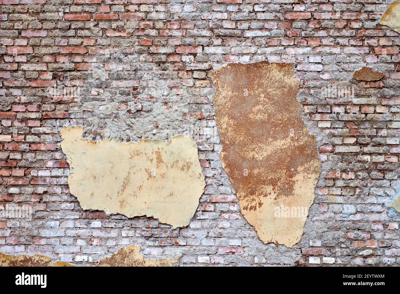 Old brick wall with broken stucco and plaster. Abstract brick texture