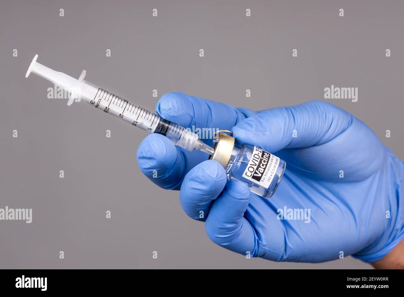 Closeup of hand with surgical glove insert syringe into covid19 vaccine vial Stock Photo Alamy