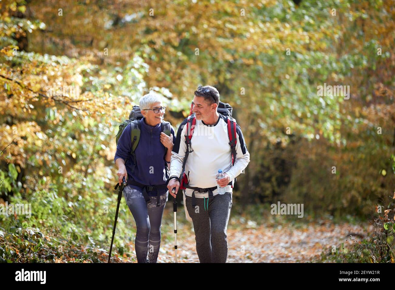 Cheerful elder couple hiking in forest Stock Photo
