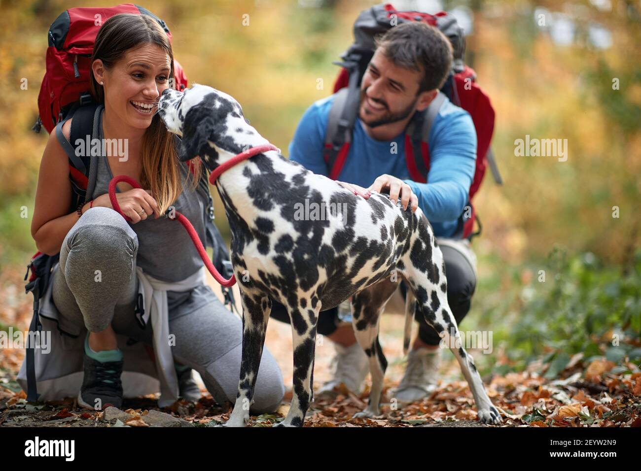 Cheerful man and woman hiking and enjoying with dog Stock Photo