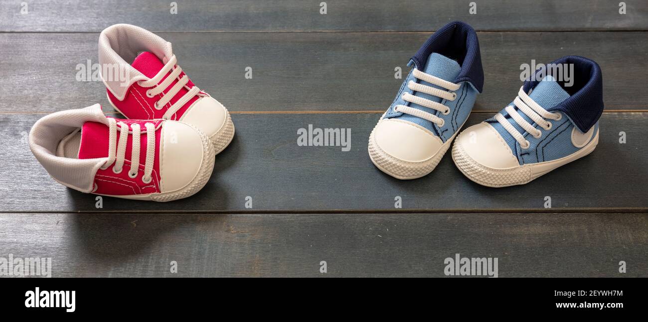 Kids sport shoes on blue wood floor background. Pink and blue baby