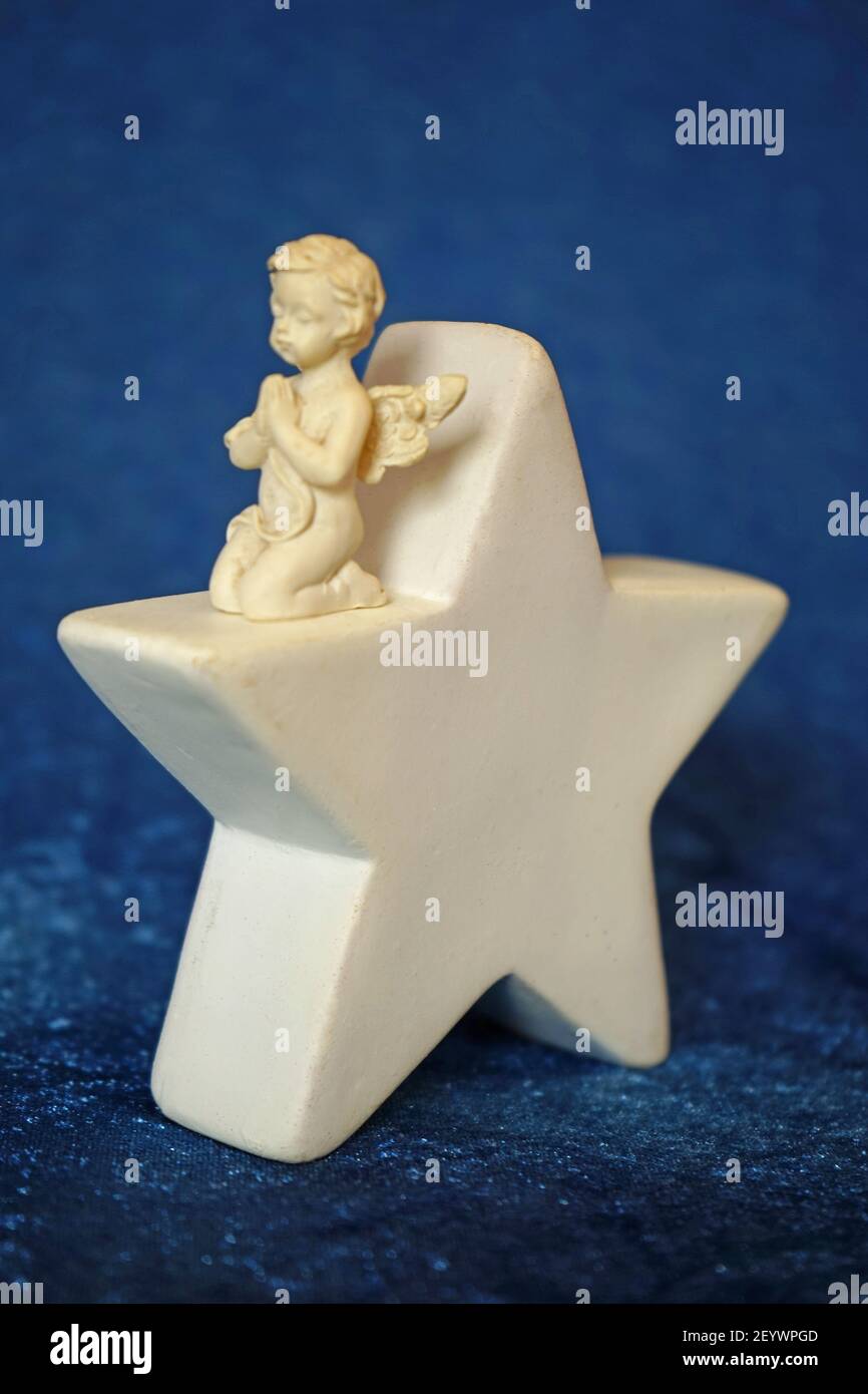 Engel, der auf einem Stern kniet. Stock Photo