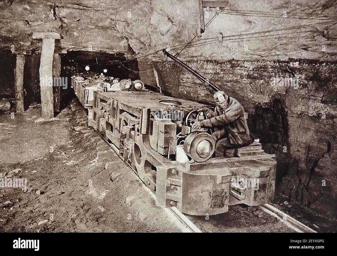 An early photograph in a coal mine showing the introduction of motorised trains to transport trucks of coal. Stock Photo