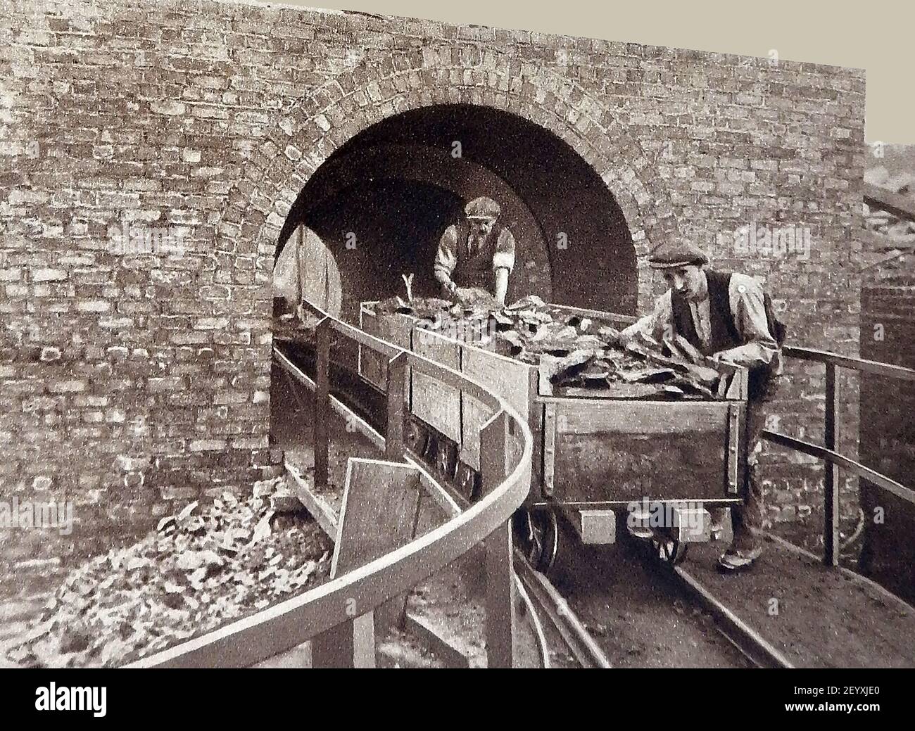 An early photograph circa 1940's showing coal miners pushing trucks of coal to the 'tippler' where pieces of coal  will be sorted for size. Stock Photo