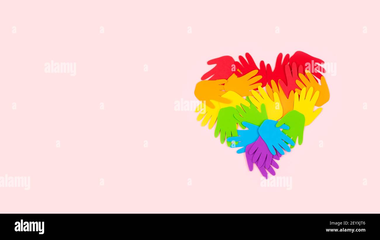 Tolerance, kindness, cooperative, friendship, charity humanitarian aid day concept. Many rainbow color palm hands on pink background with copy space Stock Photo