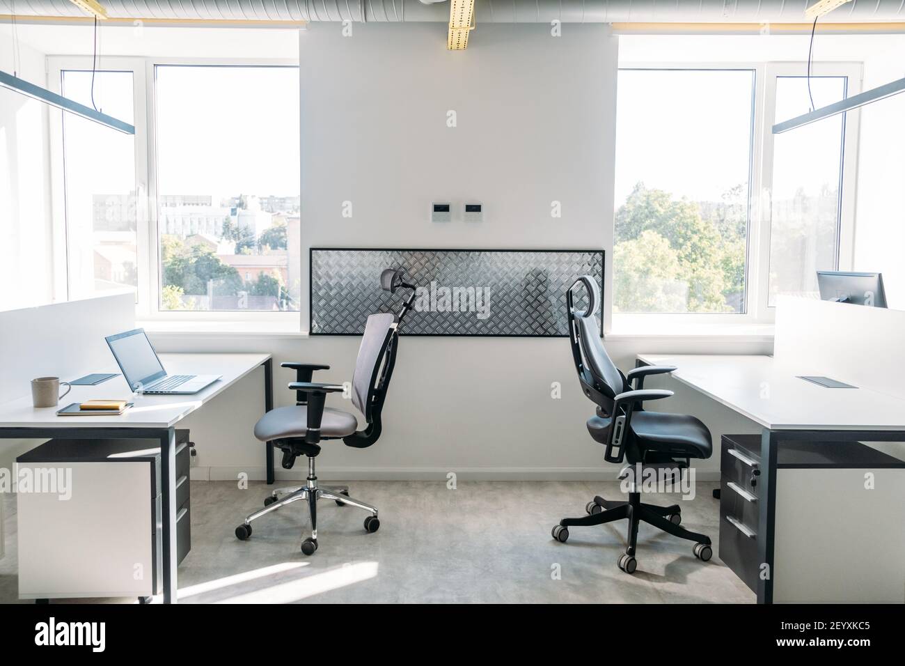 Empty office space while officer is working from home to avoid corona virus. Open space office in loft style in new normal. Working In An Empty Office Stock Photo