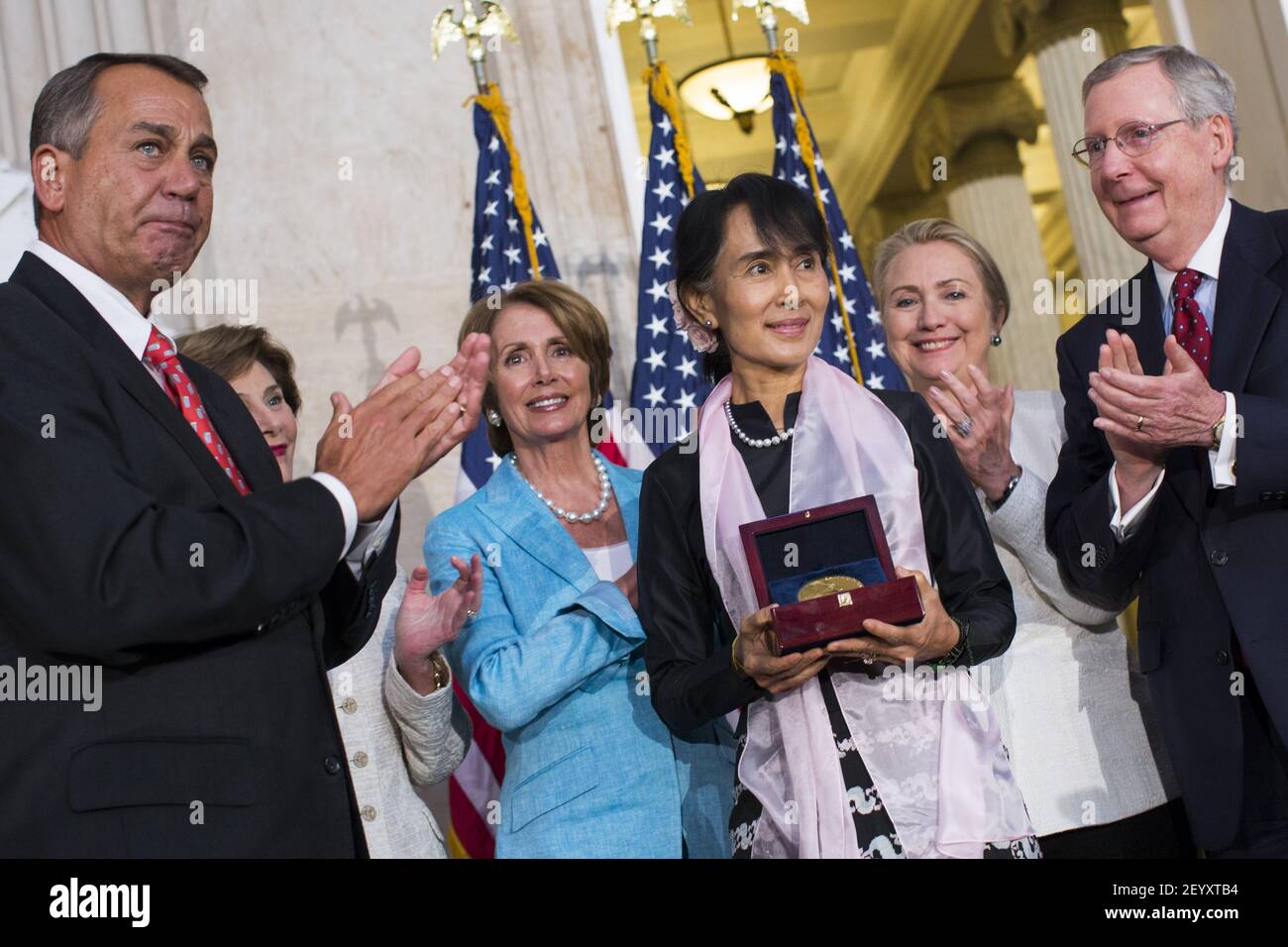 19 September 2012 - Washington, D.C. - Burmese civil rights activist Daw Aung San Suu Kyi, center, is awarded the Congressional Gold Medal during a ceremony in the Rotunda of the United States Capitol Building. Presenting the medal are (from left) Speaker Of The House John Boehner, Former First Lady Laura Bush, House Minority Leader Nancy Pelosi, Secretary of State Hillary Clinton and Senate Minority Leader Mitch McConnell. Photo Credit: Kristoffer Tripplaar/ Sipa USA Stock Photo