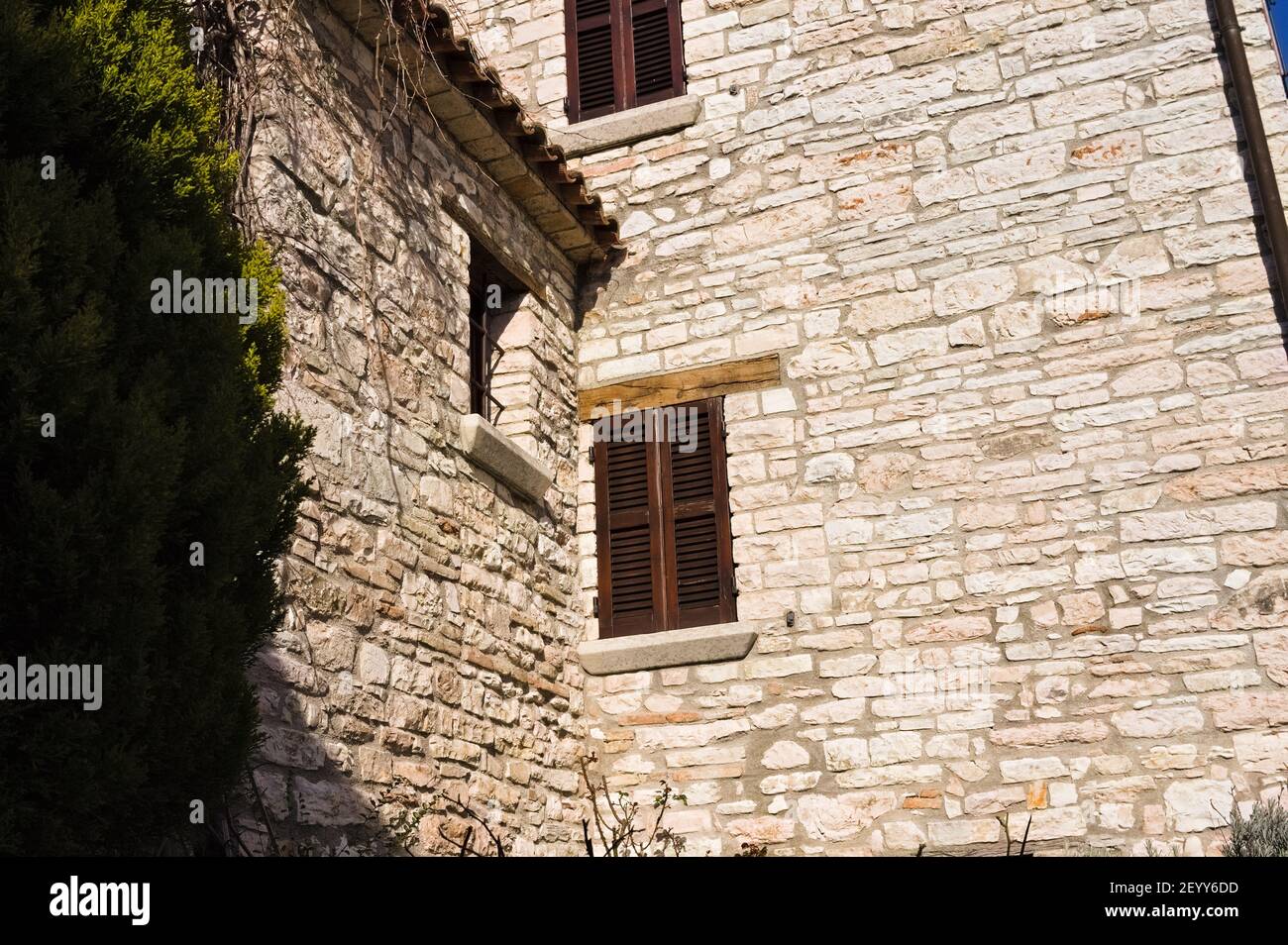 A window with wooden shutters of a medieval brick building (Marche ...