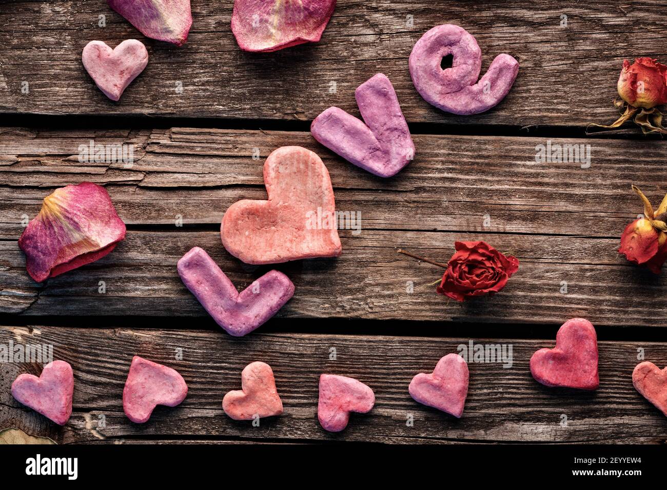 Word Love with rose petals and small heart Stock Photo