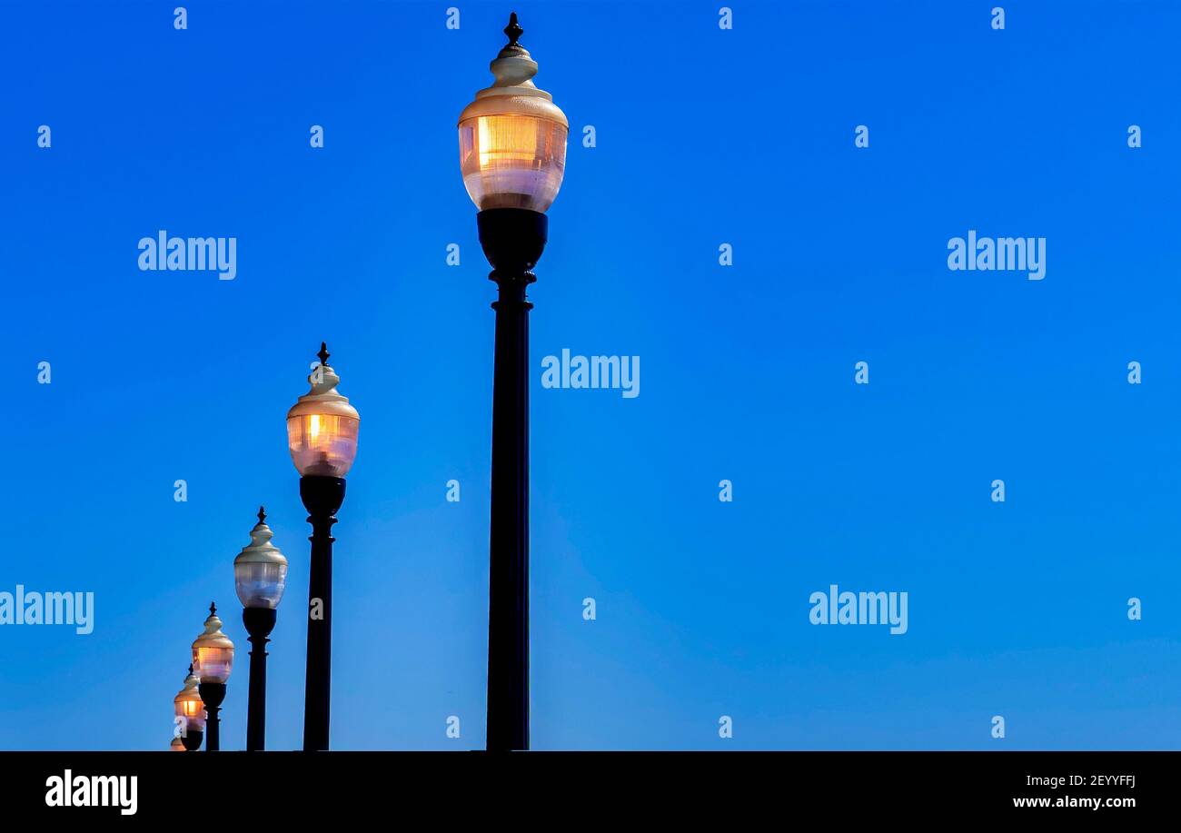 Antique style street lights glowing during the day Stock Photo Alamy
