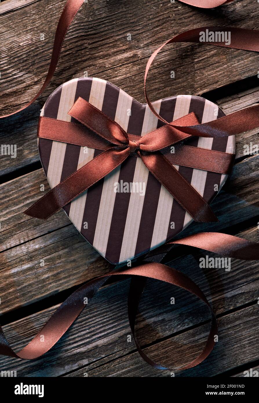 Heart shaped Valentines Day box with curved ribbon Stock Photo