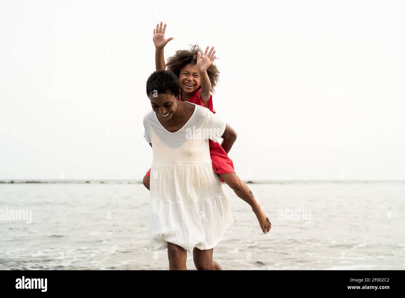 Happy African family on the beach during summer holidays Afro