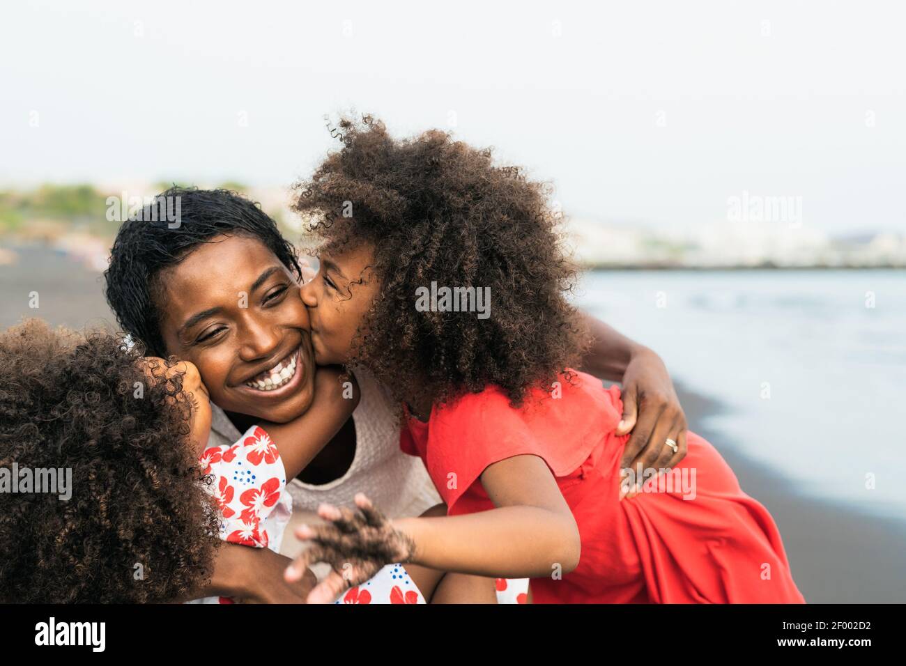 Happy African family having fun on the beach during summer holidays - Afro people enjoying vacation days - Parents love and travel lifestyle concept Stock Photo
