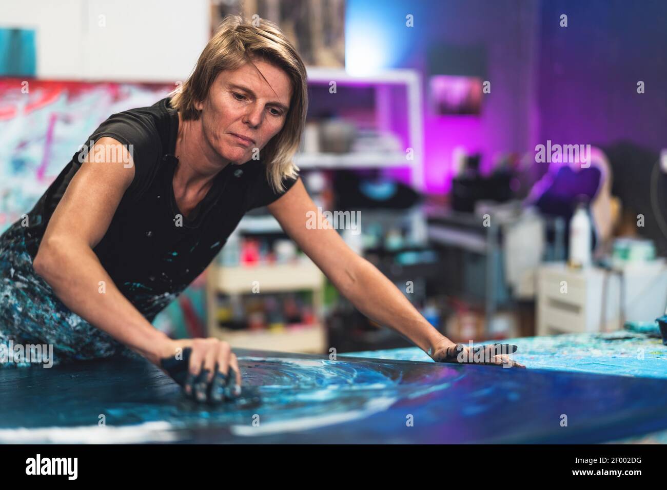 Female artist painting on canvas in workshop studio - Painter work and creative craft concept Stock Photo