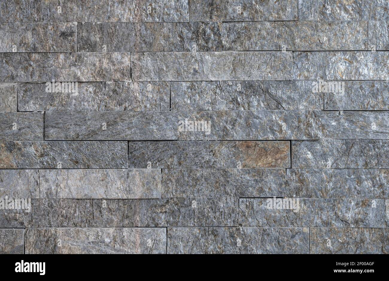 The texture of the natural stone cut in the shape of the tiles on the wall Stock Photo