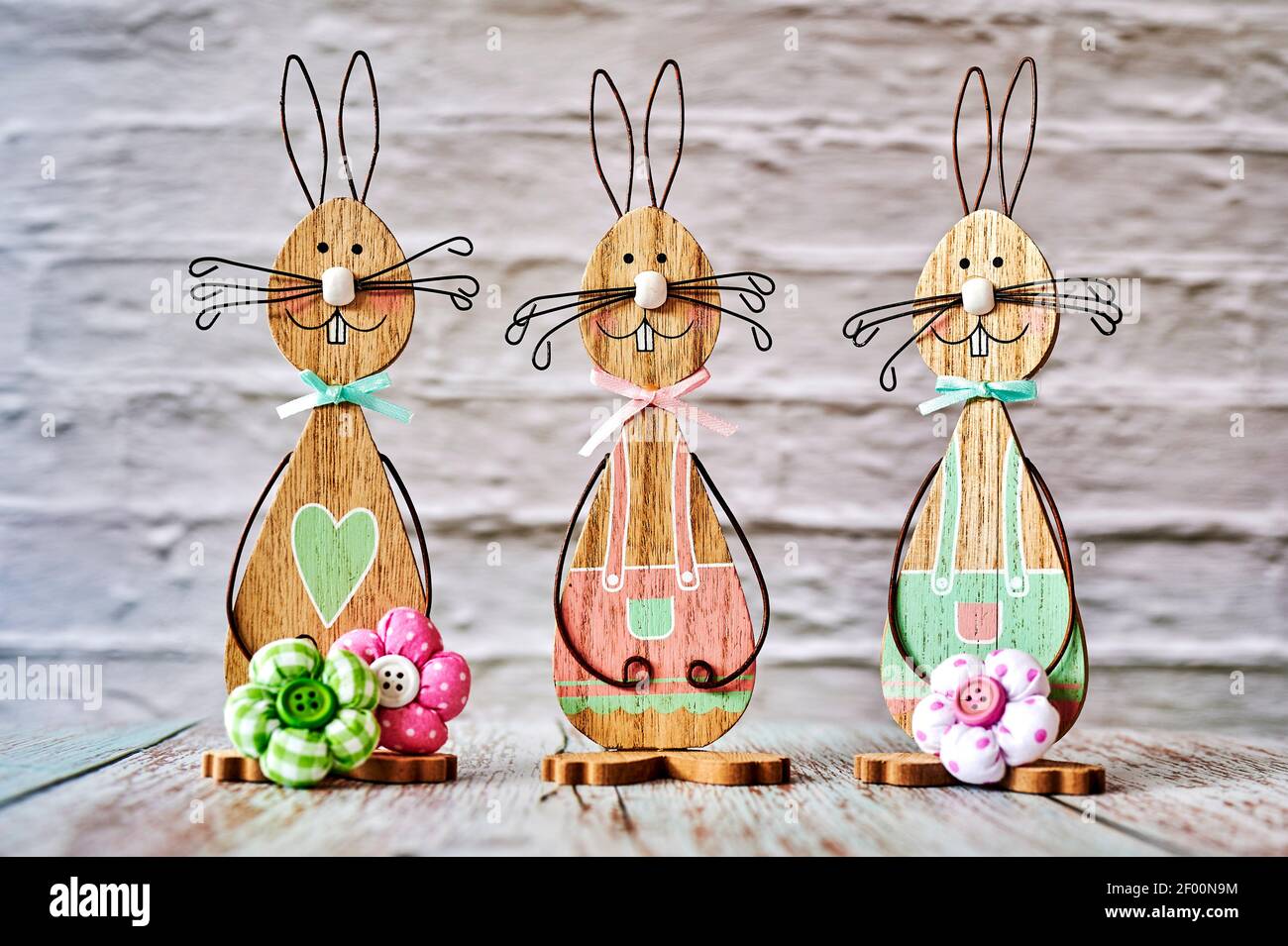 Three wooden Easter bunnies with decoration. Stock Photo