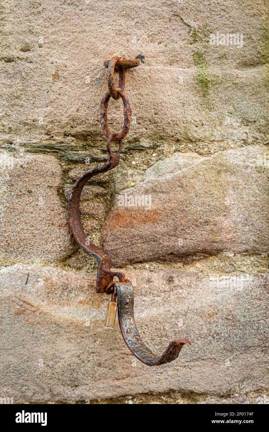 Metal collar chain for prisoners attached to a stone wall at the