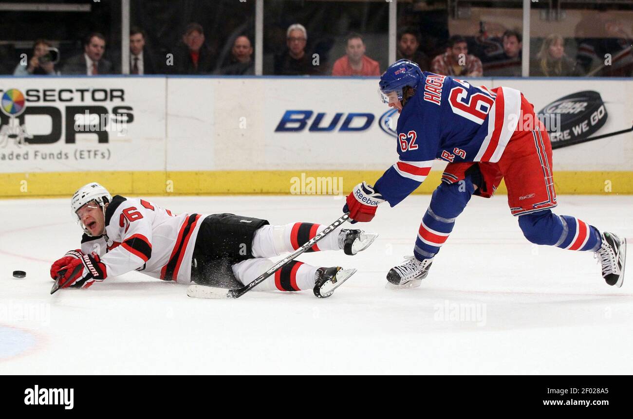 The New York Rangers' Carl Hagelin (62) commits an interference penalty  against the New Jersey Devils' Patrik Elias (26) during game action at  Madison Square Garden in New York City, Monday, February