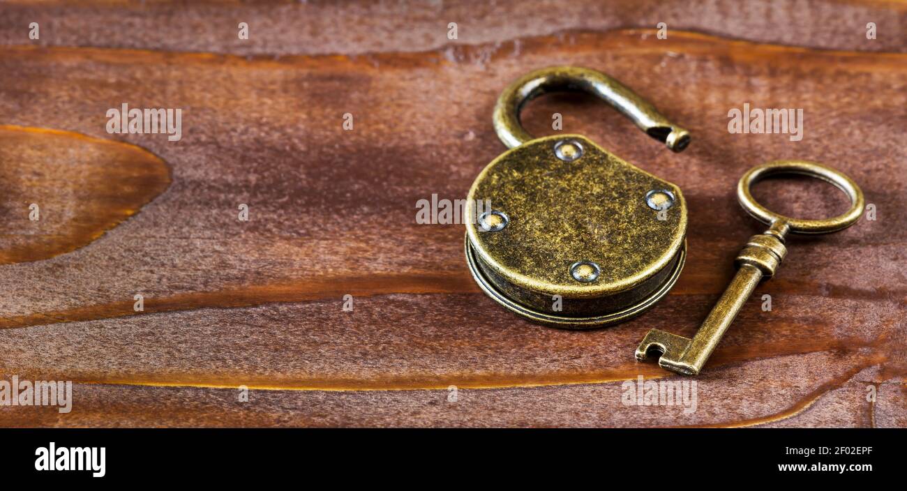 Escape room game concept, old vintage golden key and padlock. 