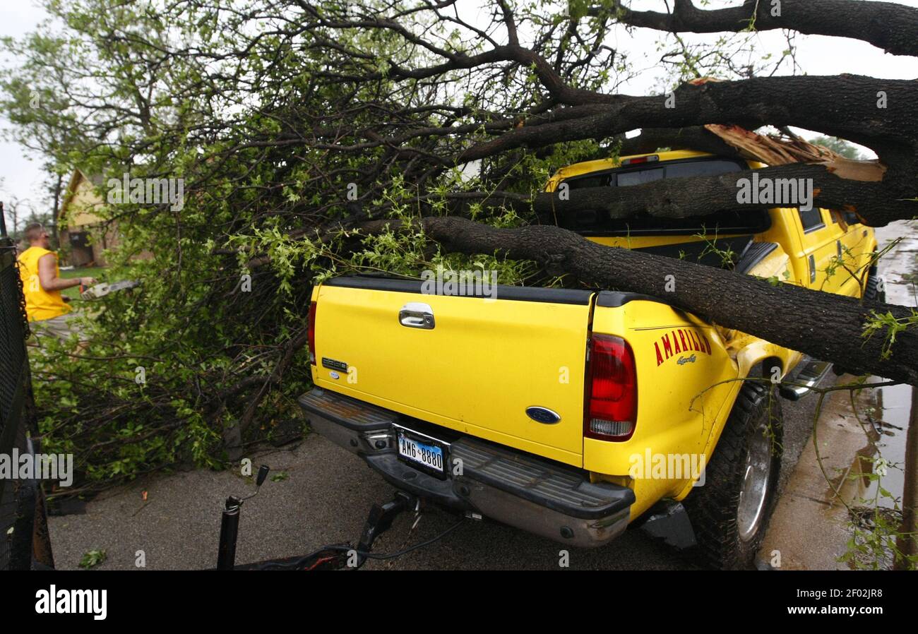 Harold Widner clears a fallen tree from his truck in Arlington, Texas ...