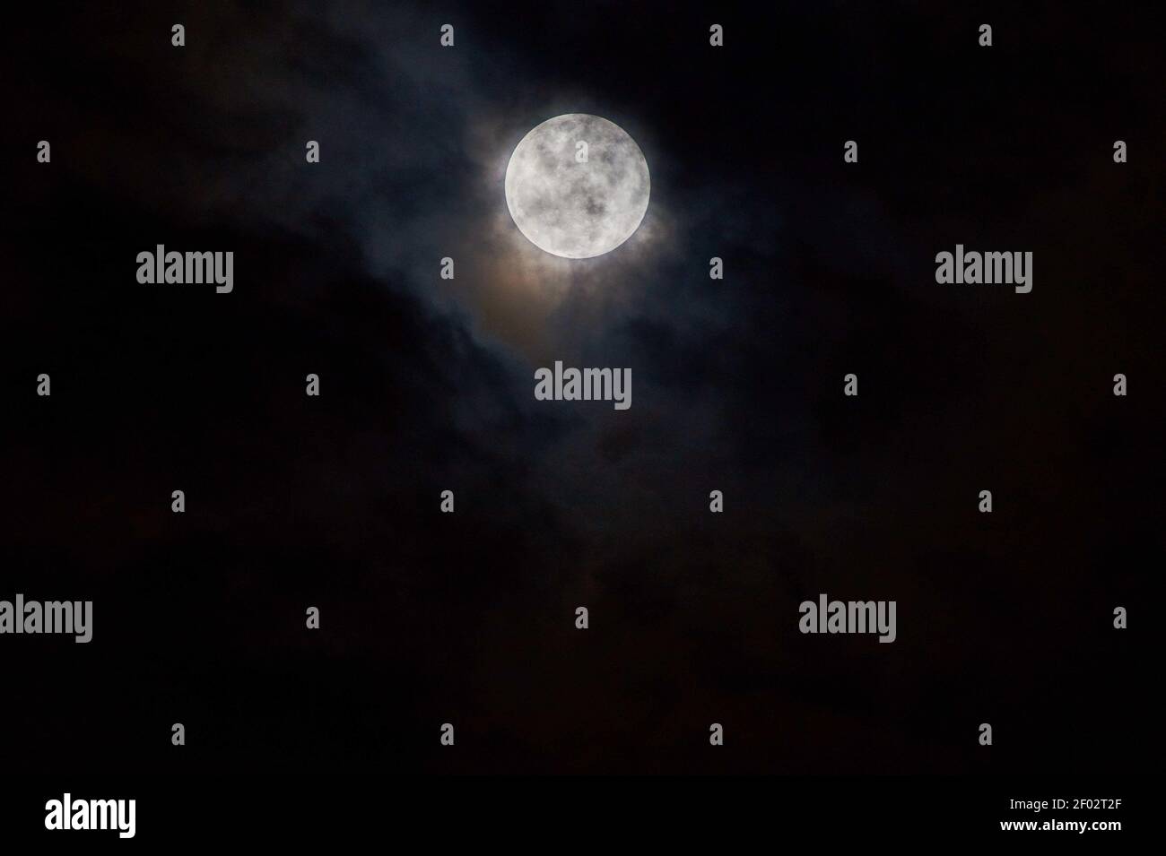 The bright full moon shining in the dark sky with black background ...