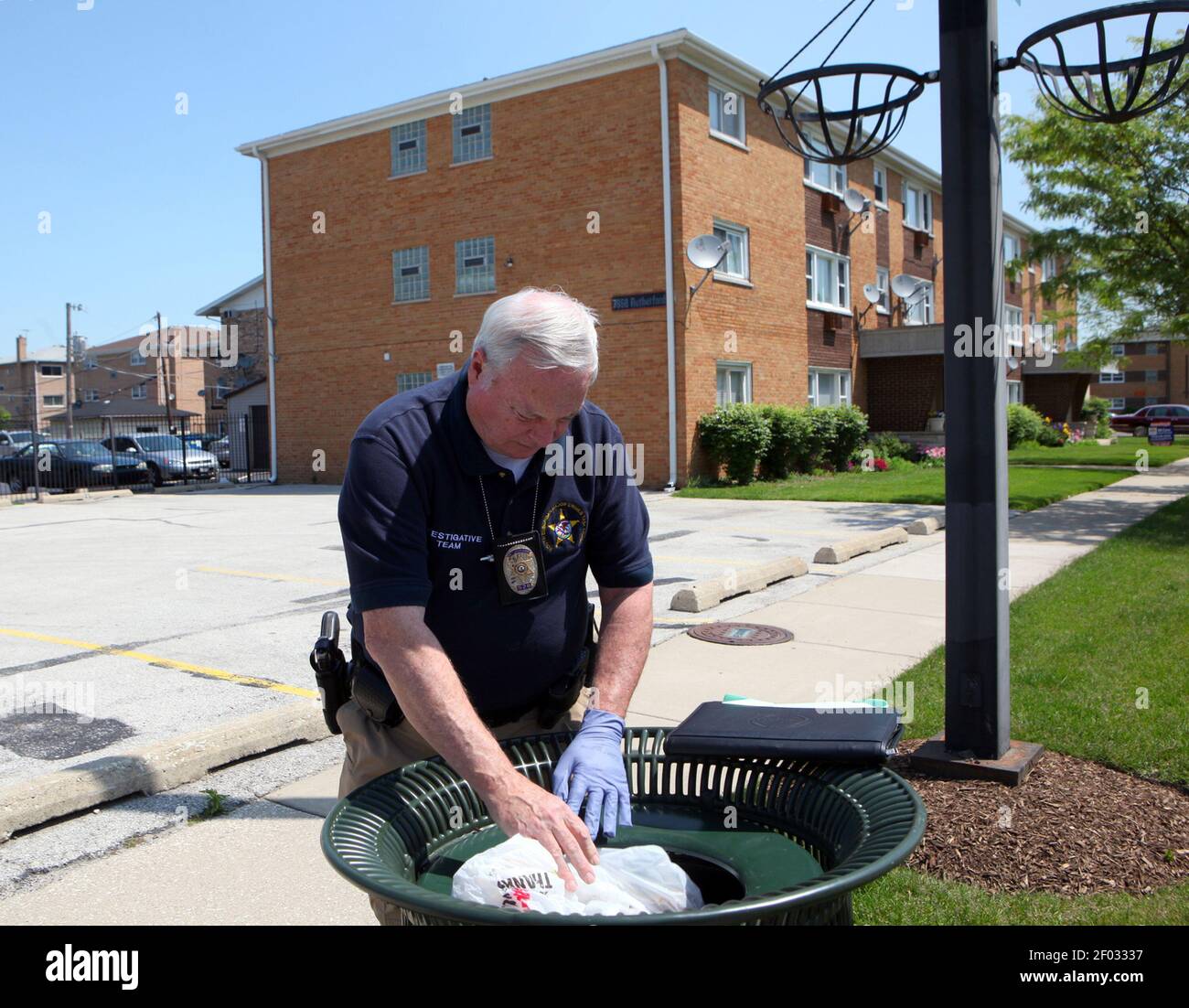 South Suburban Major Crimes Task Force investigators survey the area,  including looking into trashcans, around the apartment building where Estrella  Carrera was found stabbed to death, Monday, May 14, 2012 in Burbank,