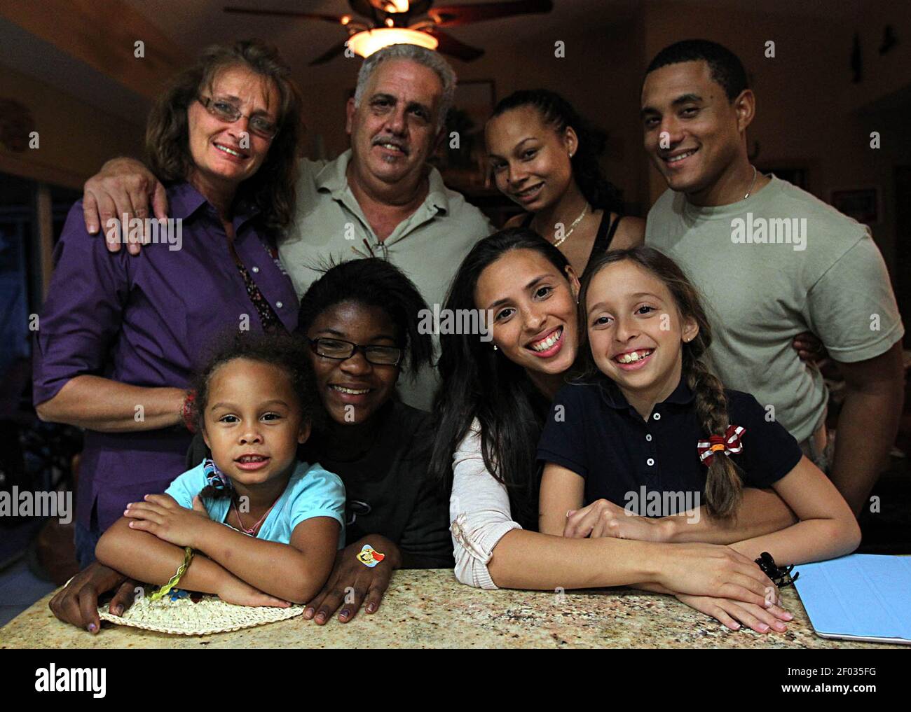 Lisa and Jorge Alvarez, with their family, from left, sitting,  granddaughter Noemi, daughters Natasha and Vanessa, granddaughter Mya,  back, daughter Kathy Remos and her fiancee, Brandon Phillips, at home in  Kendall, Florida